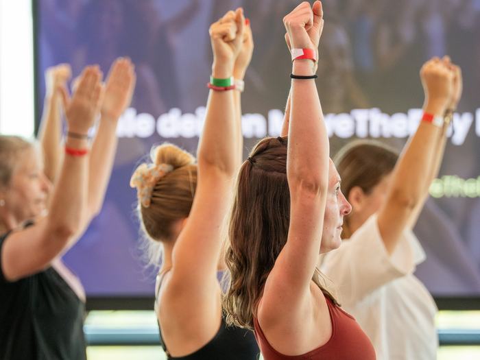 Teilnehmerinnen strecken bei MoveTheDay jubelnd die Arme nach oben